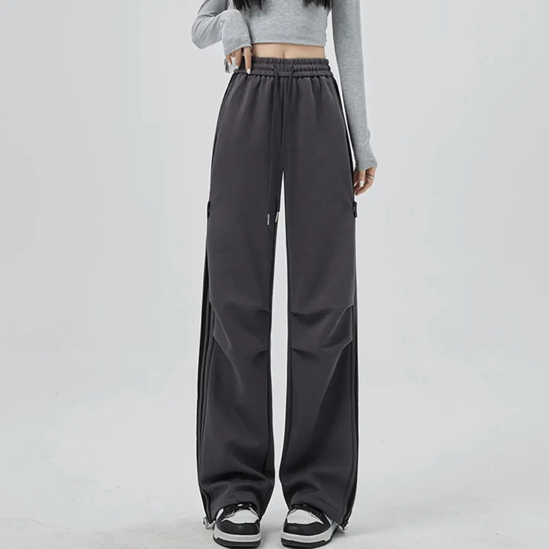 Black wide-leg pants with bold side stripes, oversized pockets, and relaxed sporty silhouette