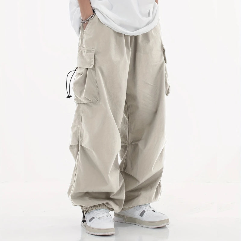Malvor wide-leg cargo pants in neutral tone, loose tapered fit with drawstring cuffs and utility pockets
