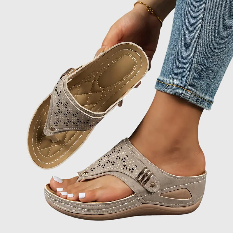Women's wedge toe loop sandals in neutral tone with intricate floral laser-cut upper detail