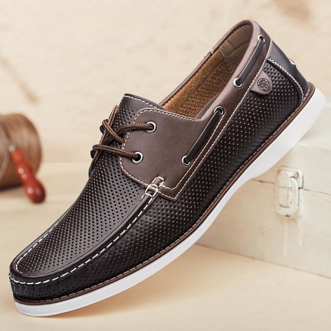 Navy blue perforated leather slip-on loafers with cushioned insole and lightweight rubber outsole