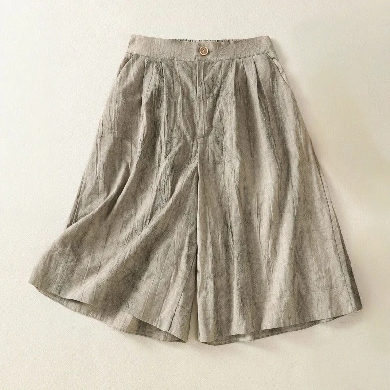 Leona wide-leg linen shorts in natural tan with button-front waist and relaxed skirt-like silhouette
