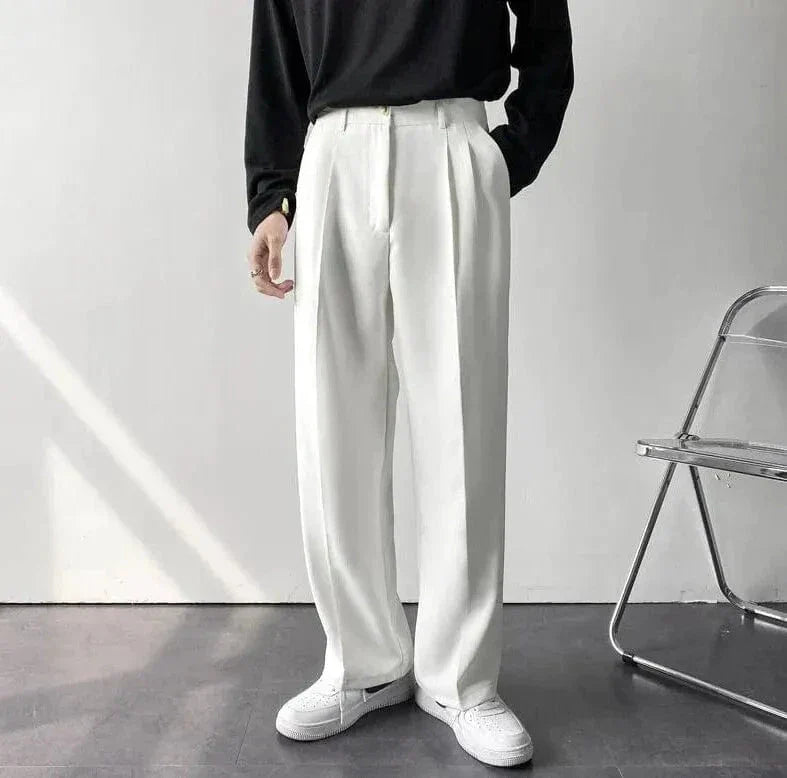Matt wide-leg pants in neutral tone with tailored pleat detail and relaxed flowing silhouette