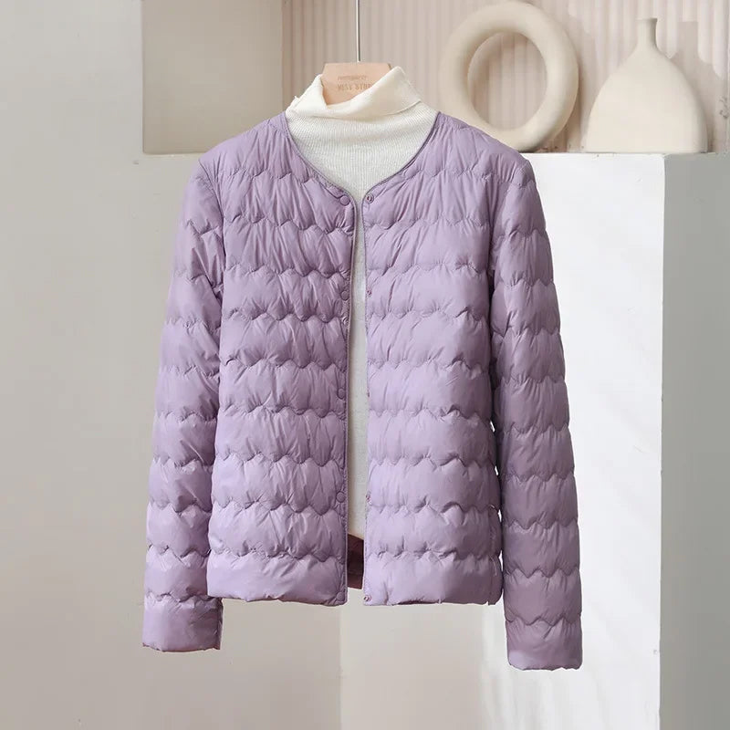 Minimalist white collarless quilted down jacket with wave-pattern stitching, sleek modern silhouette