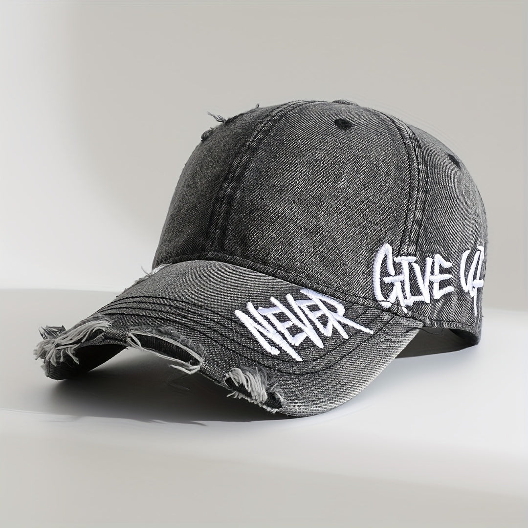 Washed denim cap with graffiti-style "Never Give Up" embroidery, frayed curved brim, unisex adjustable fit