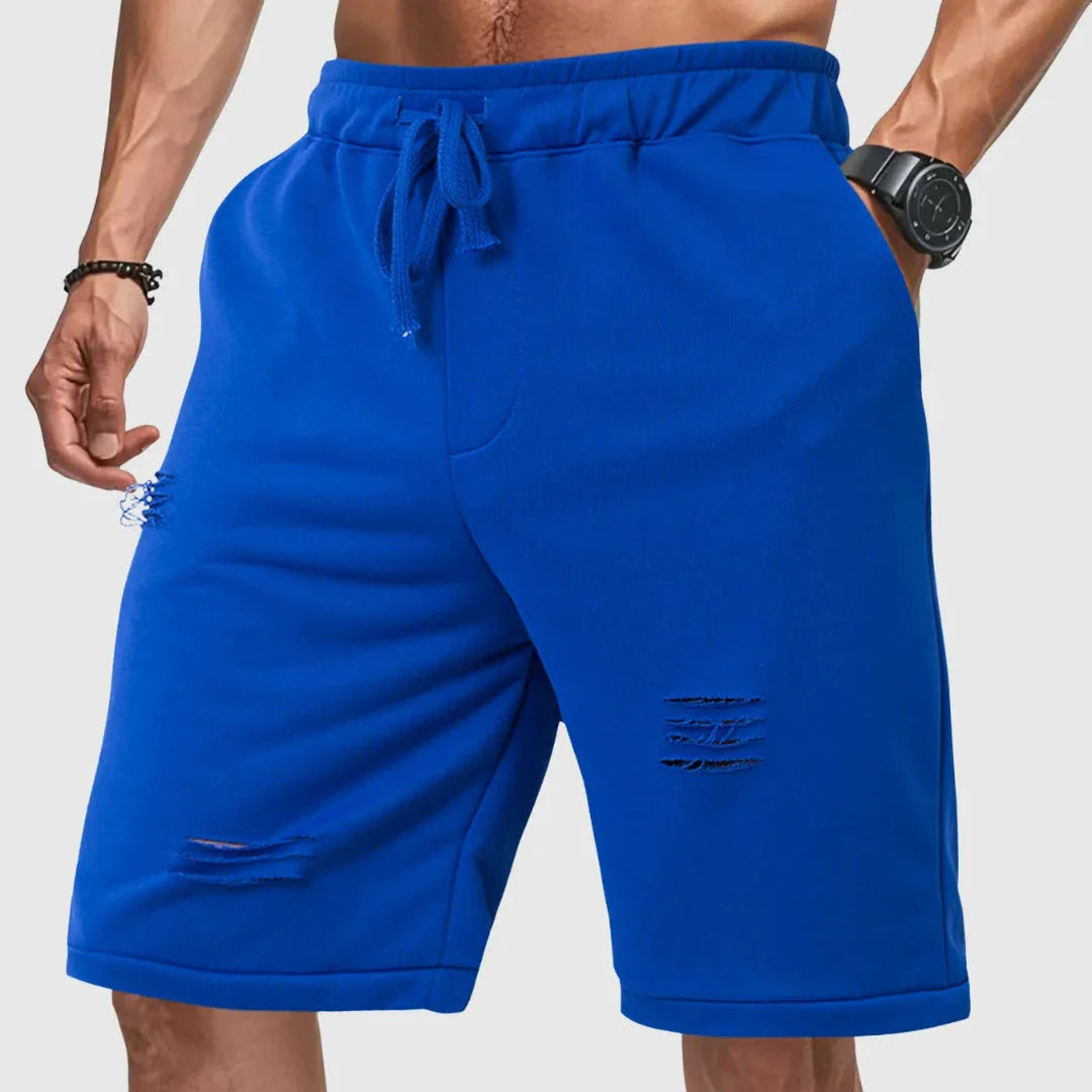 Men's gray distressed jogger shorts with relaxed fit, drawstring waist, and ripped detailing