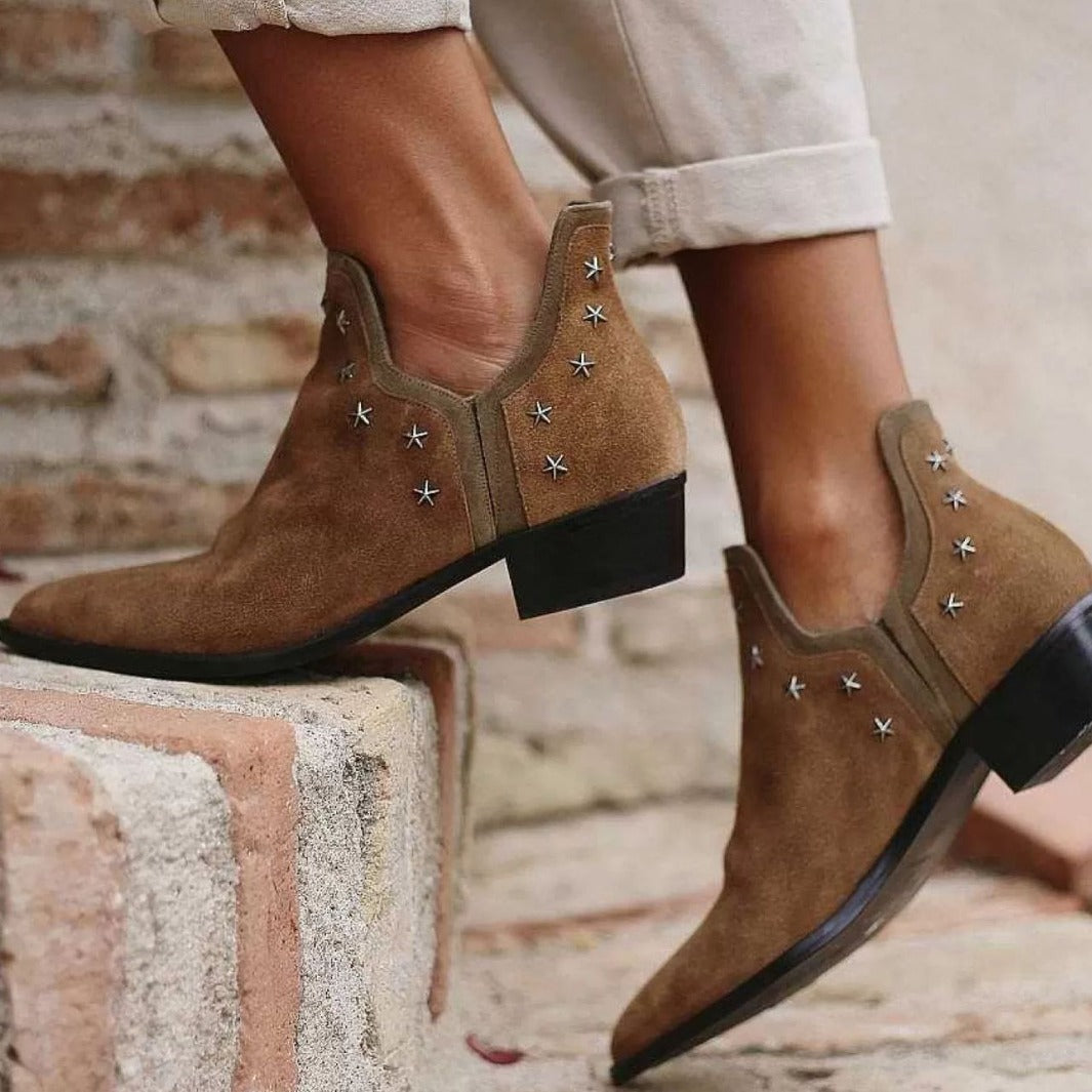 Brown studded western boots with metal stud accents and classic pointed-toe cowboy silhouette