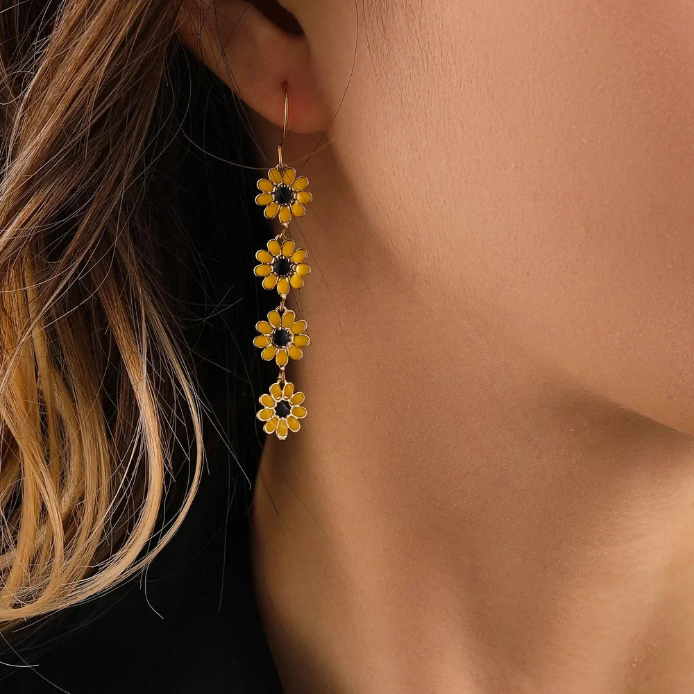 Dainty dangling daisy floral charm earrings in gold-toned copper, lightweight tarnish-resistant spring design