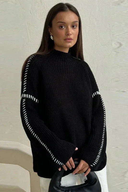 Oversized patchwork knit jumper in bold color contrasts with mock neck and flared sleeves