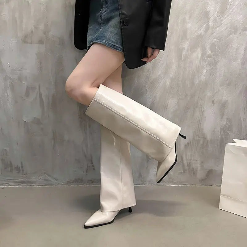 Women's black leather thigh-high boots with structured shaft and bold buckle detail