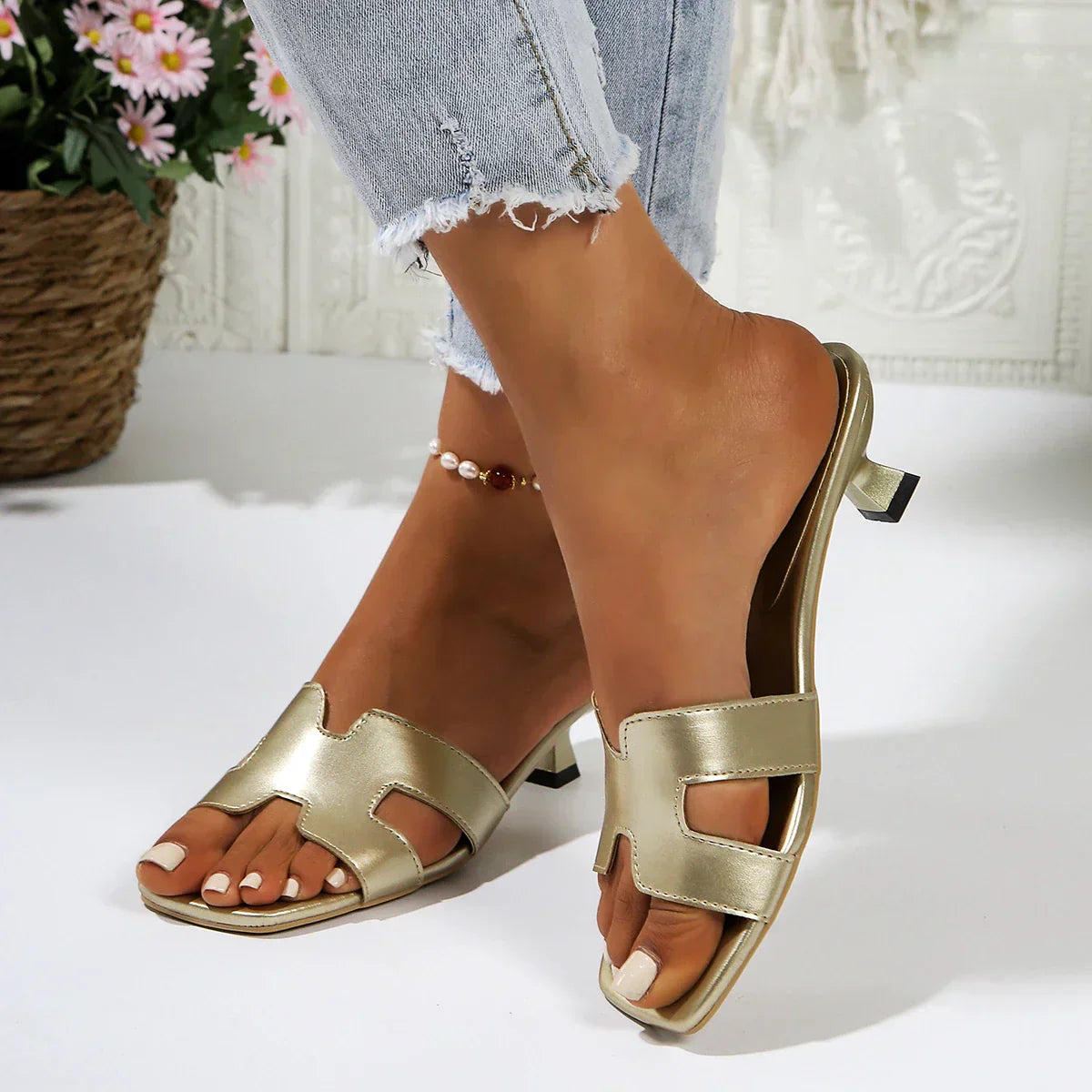 Women's low heel flat sandals in elegant neutral tone with delicate feminine silhouette and refined strap design