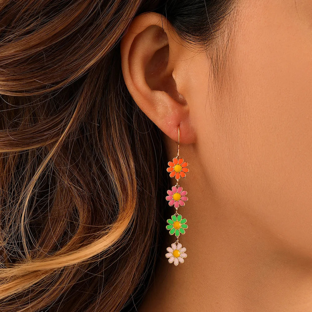 Dangling daisy chain earrings with stacked blooms, lightweight design for playful and carefree style