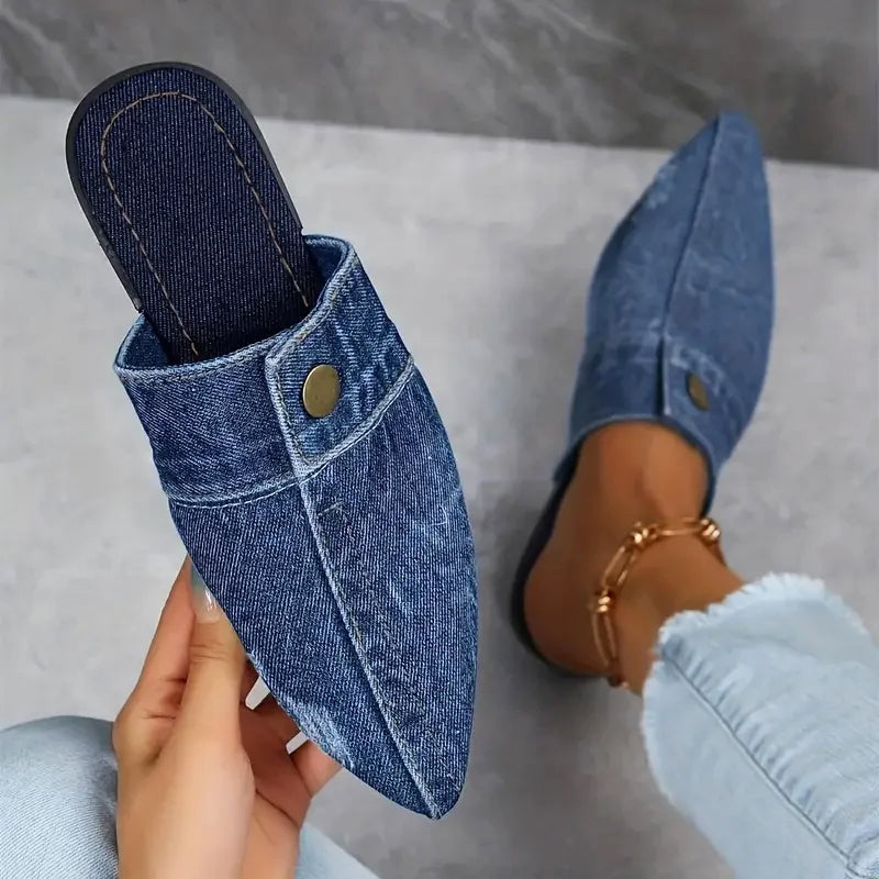Light-wash denim pointed-toe mule flats with open-back design and gold burnished stud accent