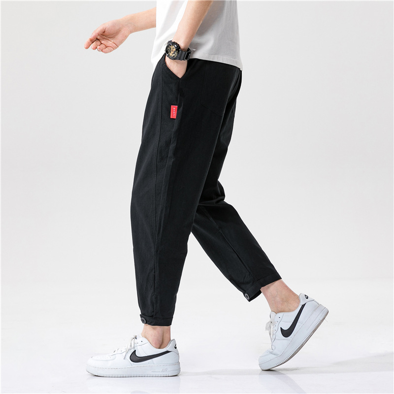 Tapered cropped linen trousers relaxed tailoring minimalist design with signature red tag accent