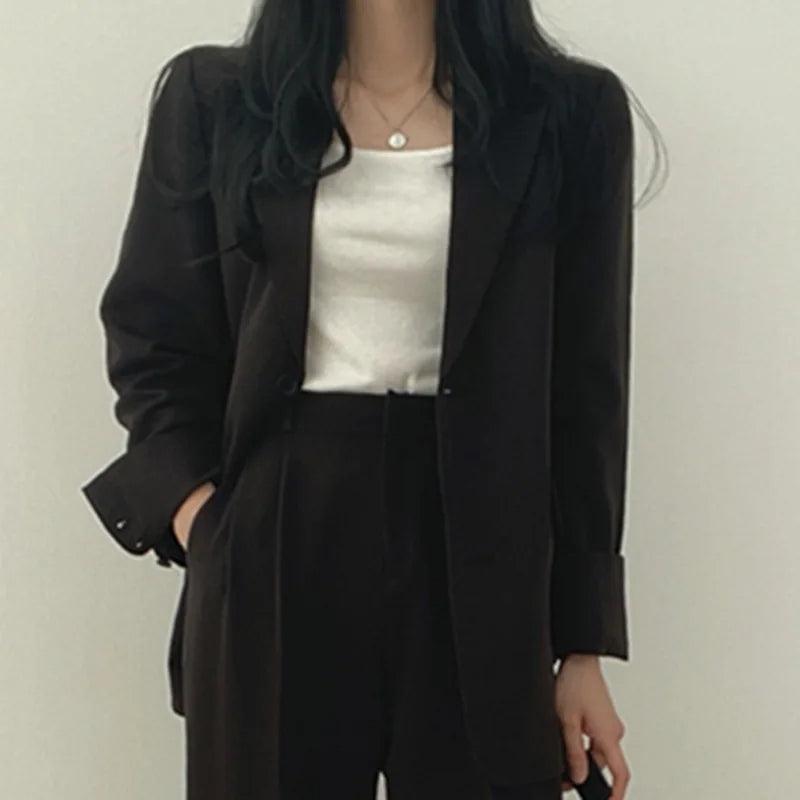 Women's tailored suit set with long structured blazer and high-waisted trousers in classic tone