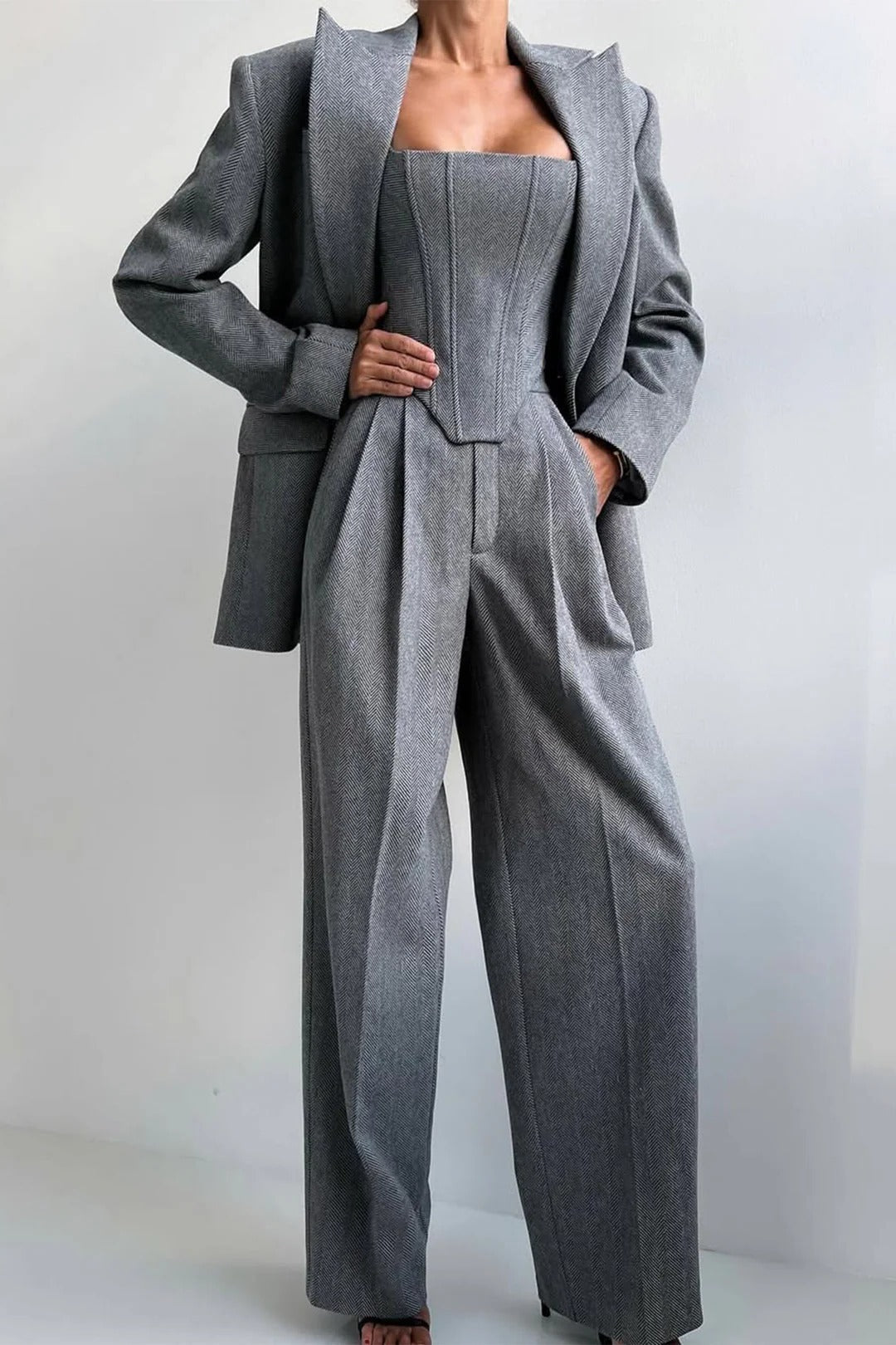 Women's black three-piece formal suit set with tailored blazer, fitted top, and wide-leg trousers