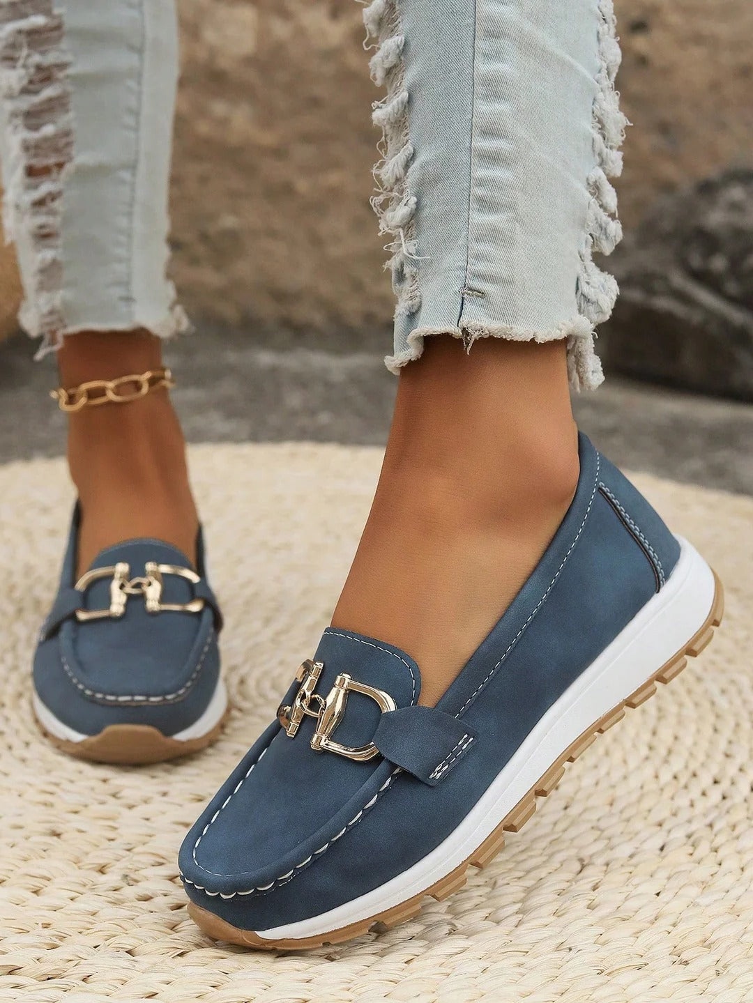 Women's slip-on loafers in neutral tone with flat wedge sole and polished gold buckle detail