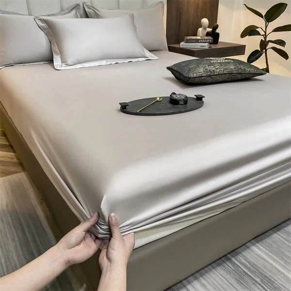 Fitted bed sheets in soft neutral tones, snug elastic edges for secure fit on deep mattresses