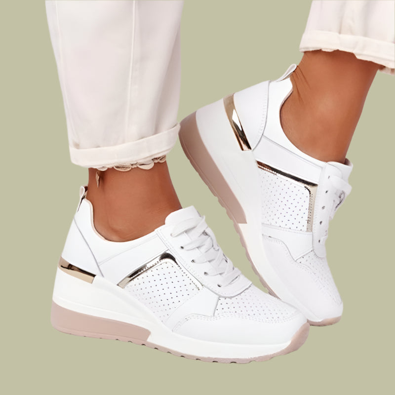 Women's white wedge sneakers with breathable perforations, lace-up closure, and hidden heel rubber sole