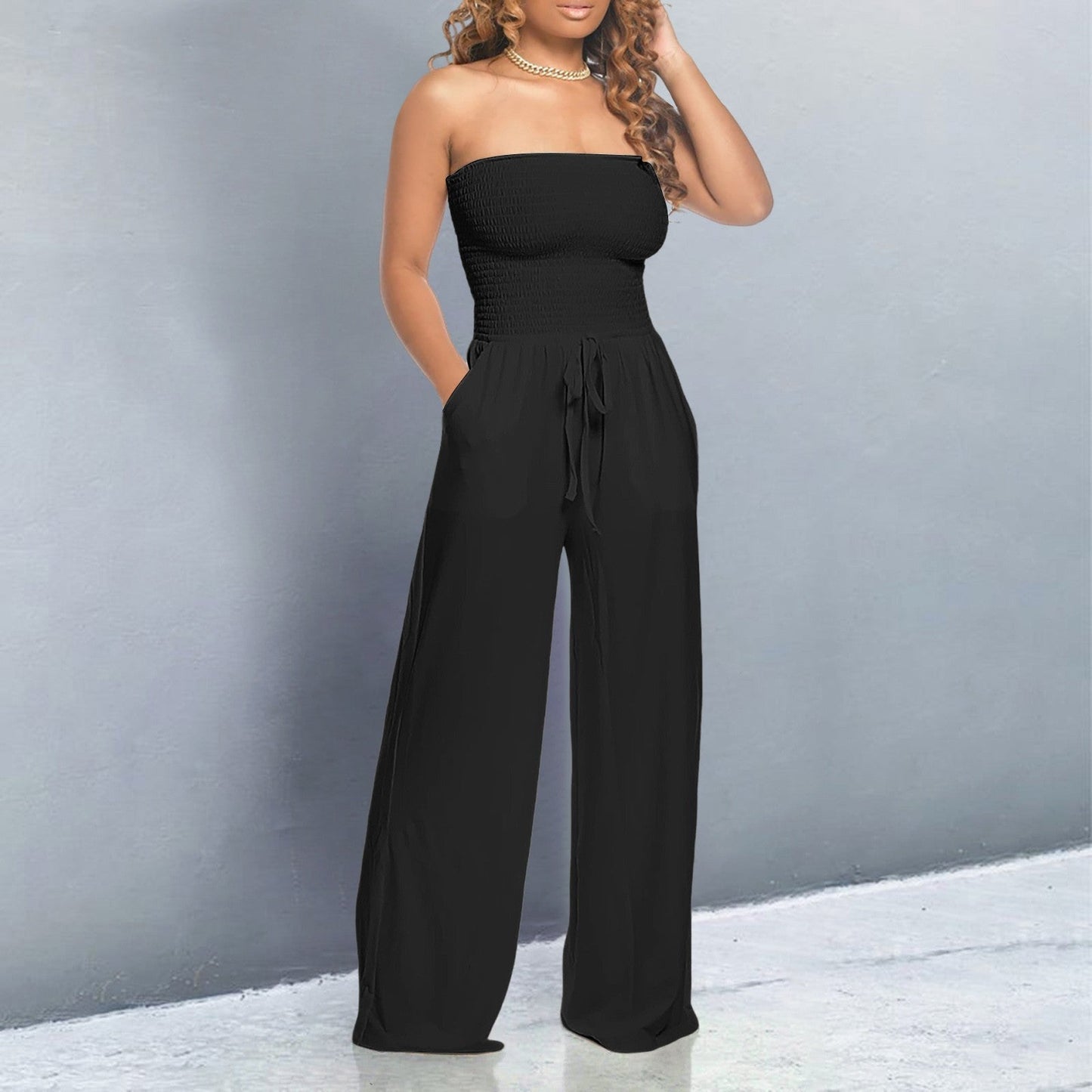 Women's black off-shoulder wide-leg jumpsuit with strapless form-fitting top and flowing silhouette