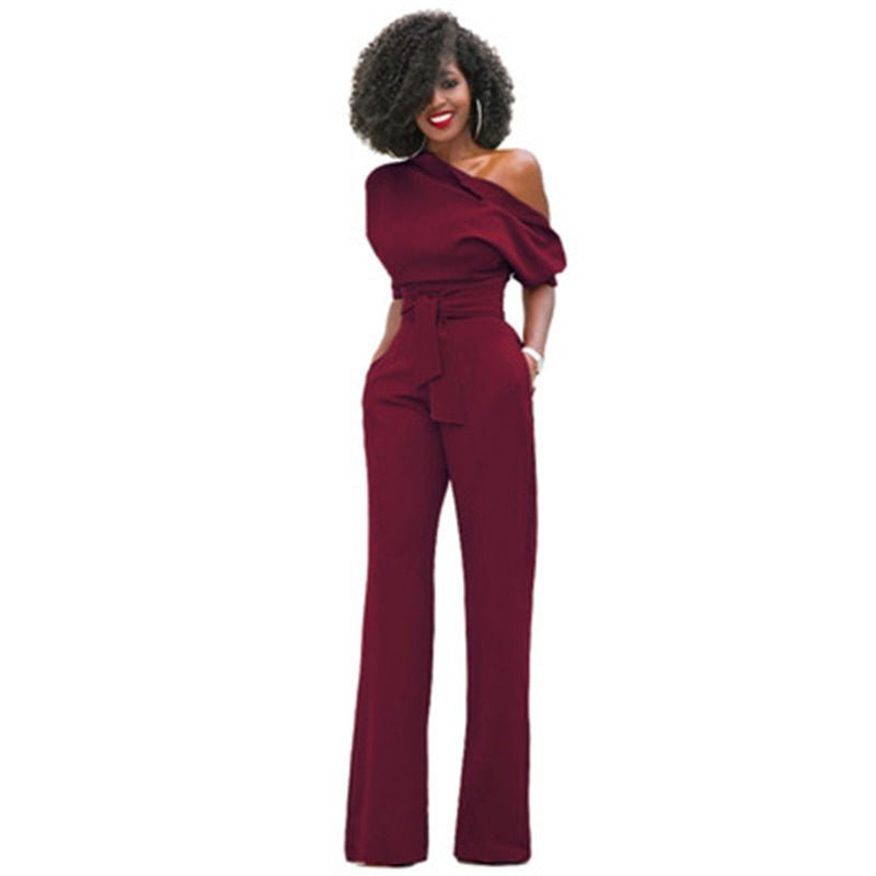 Red off-shoulder wide-leg jumpsuit with puff sleeve, belted waist, and asymmetric neckline for formal occasions
