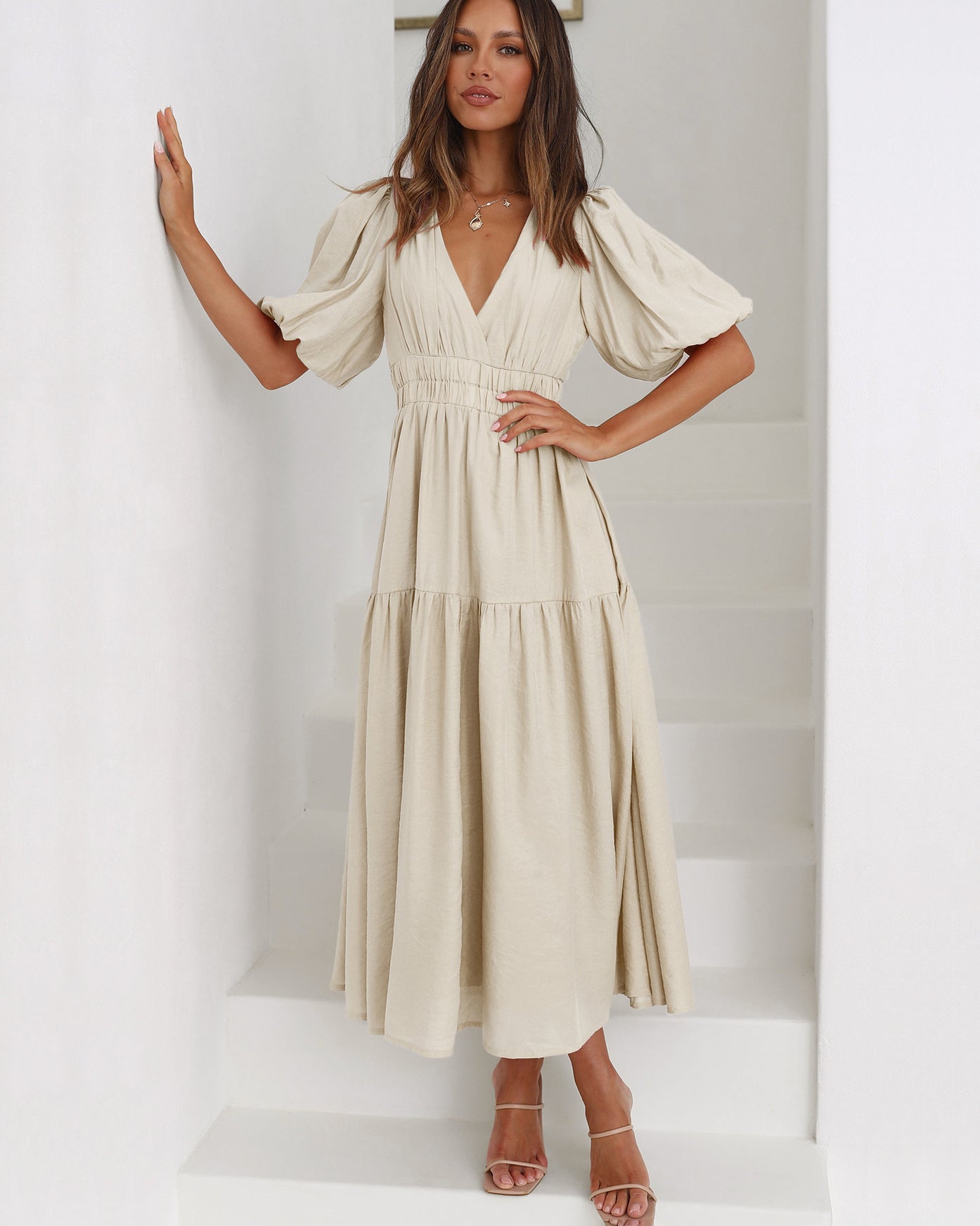 Black women's midi dress with deep V-neckline, puff sleeves, and smocked cinched waist