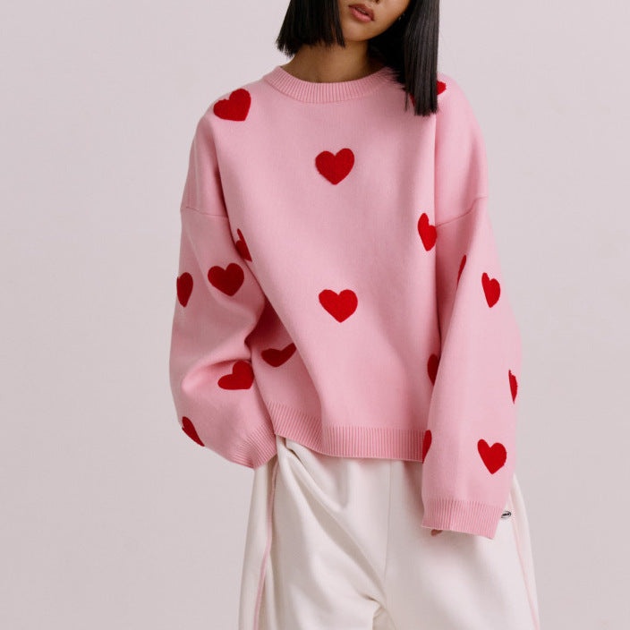 Women's oversized knit sweatshirt in neutral tone with woven red heart pattern, cozy casual fit