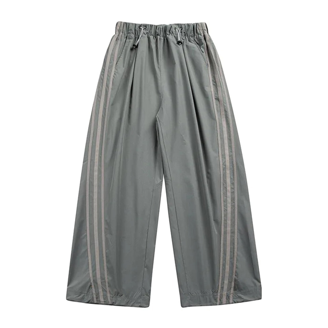 Black wide-leg drawstring track pants with side stripes, loose fit, elastic waist, lightweight nylon shell