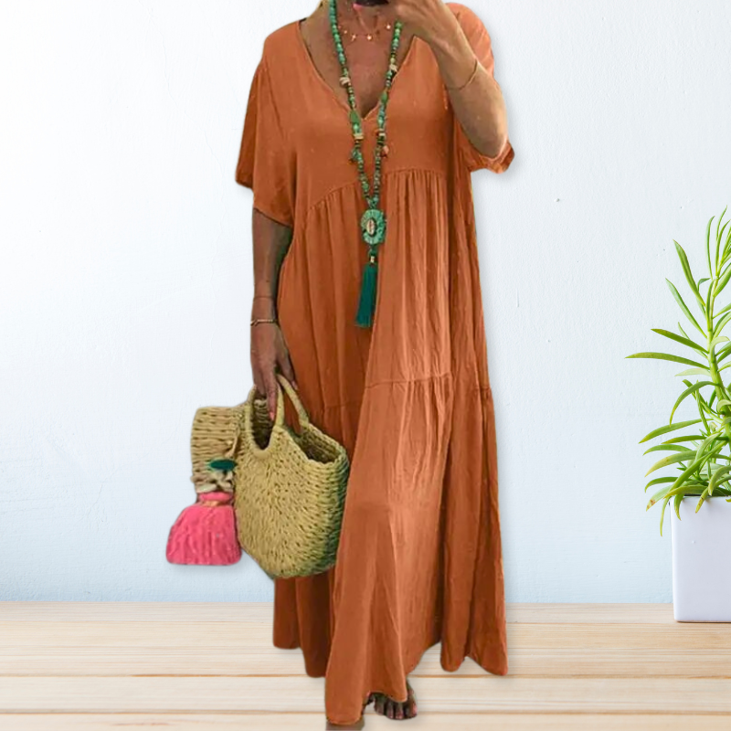 Women's draped elegant dress in soft neutral tone with flowing silhouette and graceful drape detail
