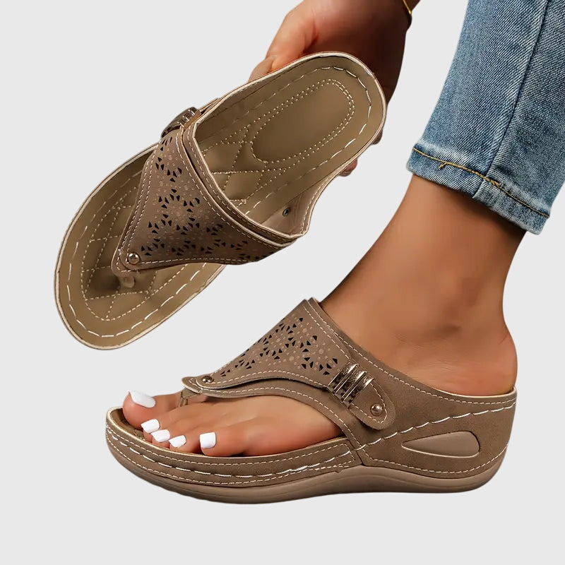 Women's wedge toe loop sandals in neutral tone with intricate floral laser-cut upper detail