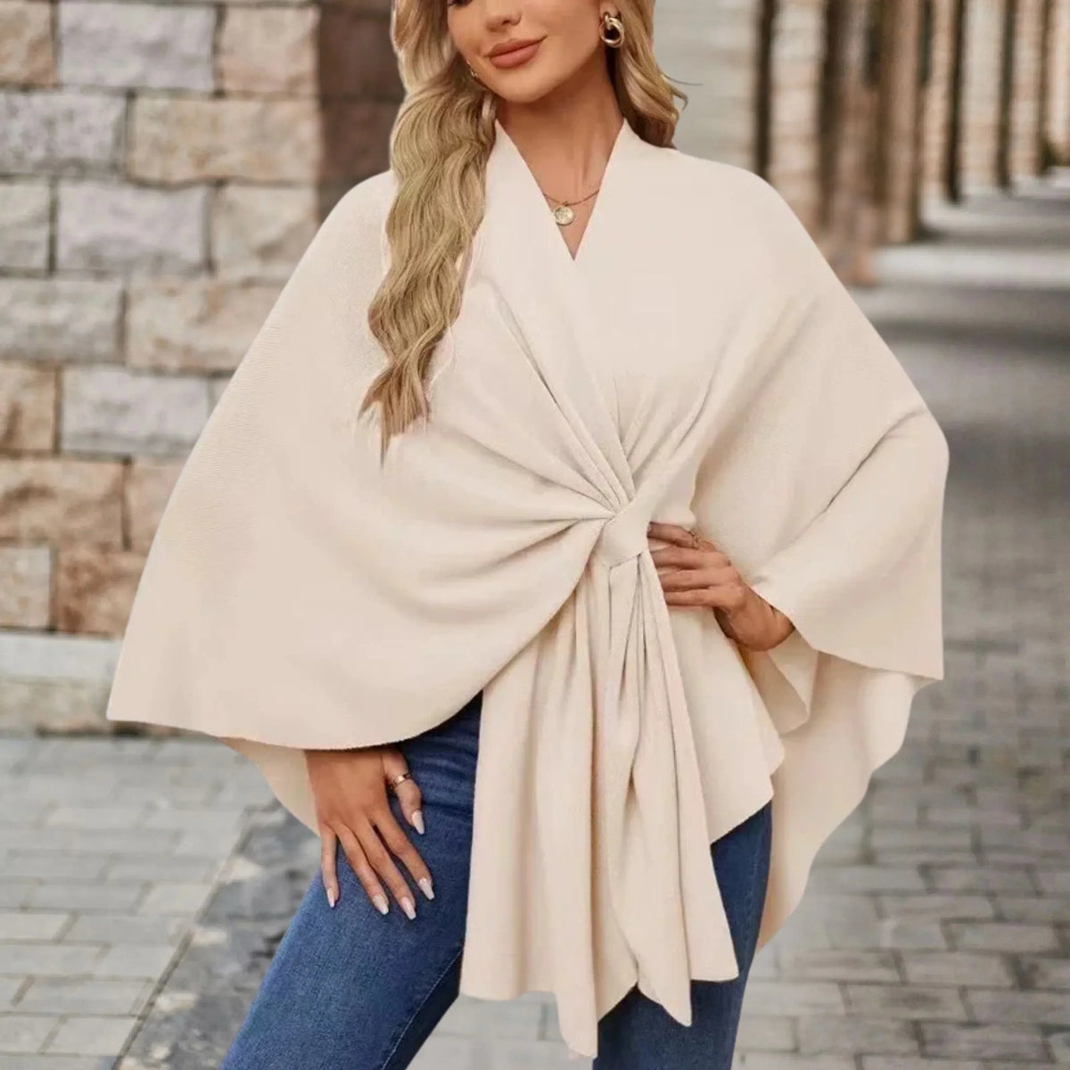 Elegant draped poncho with chic front knot in soft neutral tones, flowing silhouette women's wrap