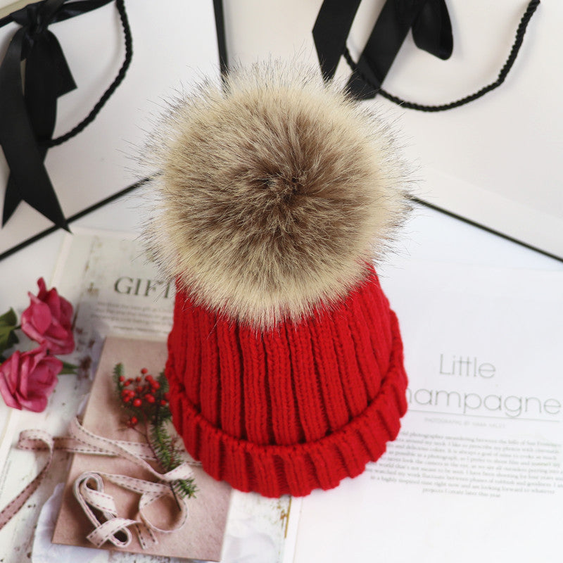 Classic cozy knit beanie in neutral tone with fluffy pom-pom accent, snug feminine winter style