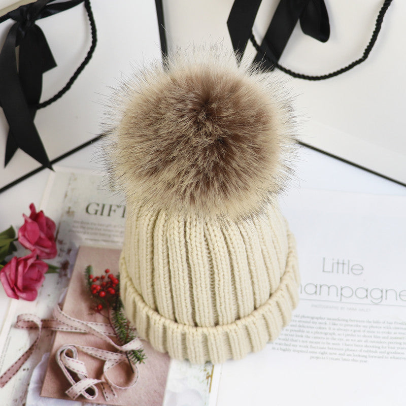 Classic cozy knit beanie with fluffy pom accent in neutral tone, snug feminine winter style