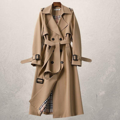 Elegant double-breasted trench coat in classic tone with cross-front closure, adjustable belt, cozy lining
