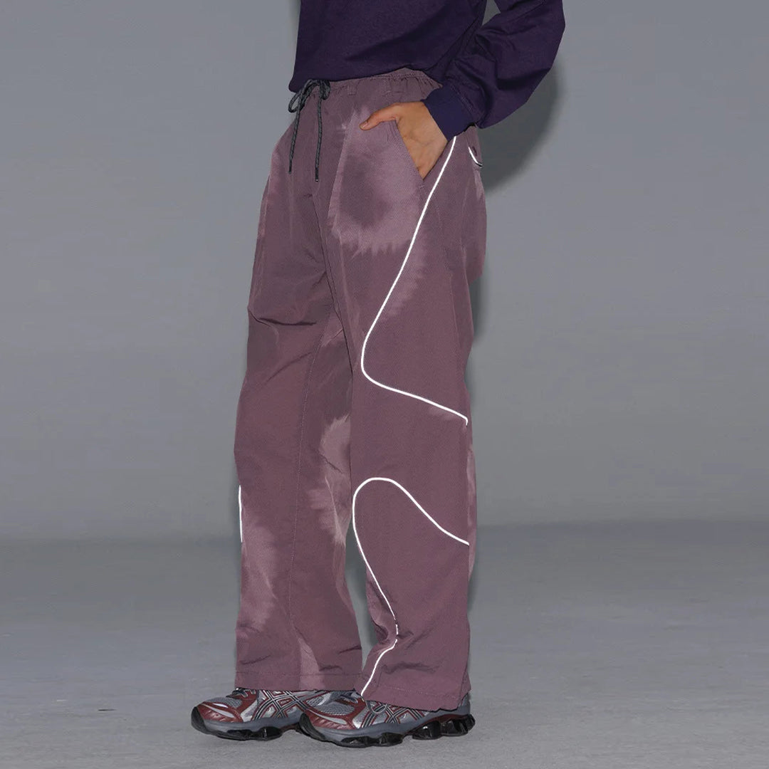 Black wide-leg nylon trousers with curved reflective stripes, elastic drawstring waist, water-resistant