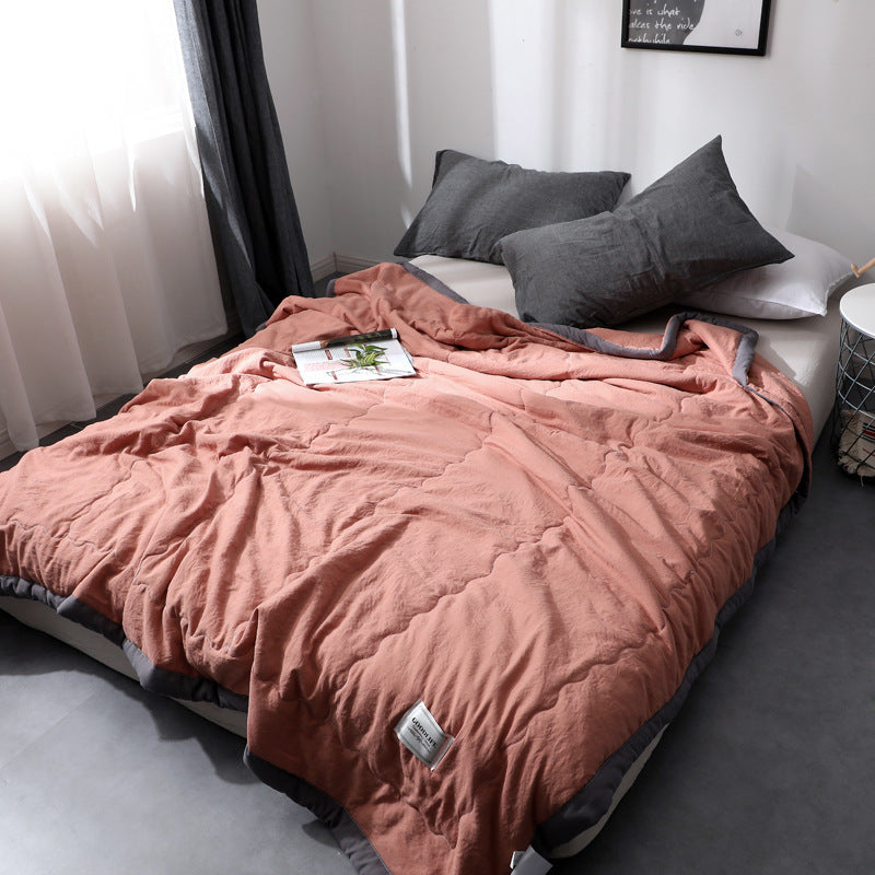 Minimalist cotton quilt blanket in soft neutral tones, lightweight breathable all-season bedroom layer