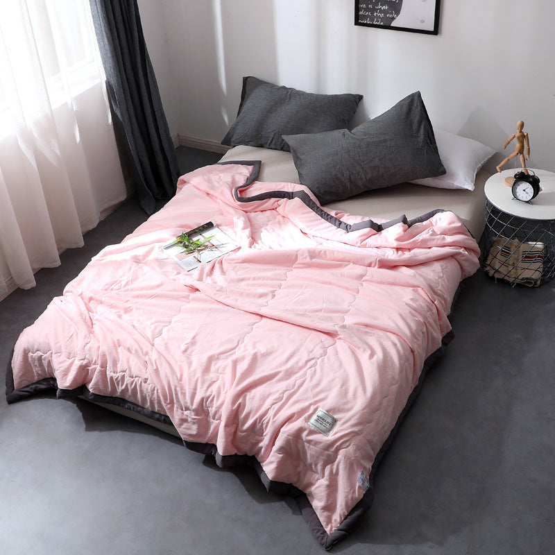 Minimalist cotton quilt blanket in soft neutral tones, lightweight breathable all-season bedding layer