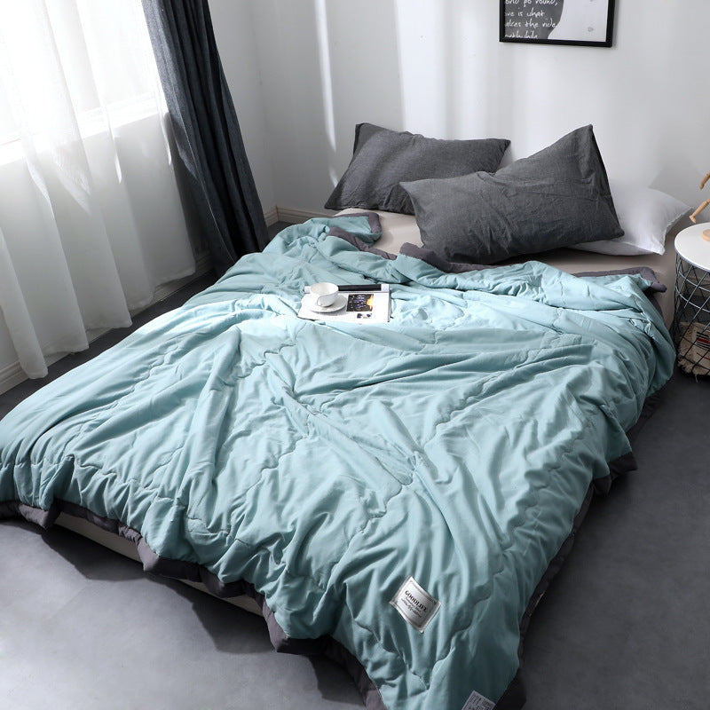 Minimalist cotton quilt blanket in soft neutral tones, lightweight breathable all-season bedroom layer
