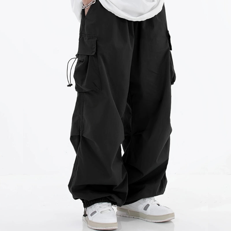 Malvor wide-leg cargo pants in neutral tone, loose tapered fit with drawstring cuffs and utility pockets