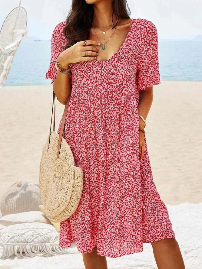 Women's navy ditsy floral smock dress with V-neck, flutter sleeves, smocked bodice, and tiered flowy hem