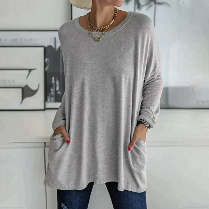Women's oversized long sleeve tunic top with front pockets, relaxed knit fit and flared hem