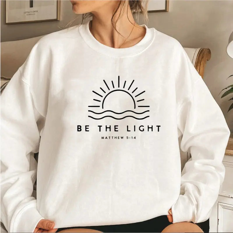 Women's Sophie Wavlynn crewneck sweatshirt in neutral fleece blend with minimalist "Be the Light" inspirational print