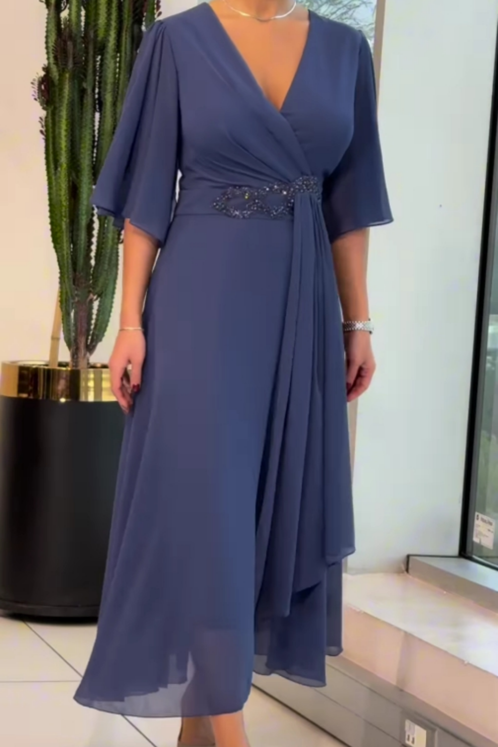 Elegant black V-neck maxi dress with flowing silhouette and elongating neckline detail