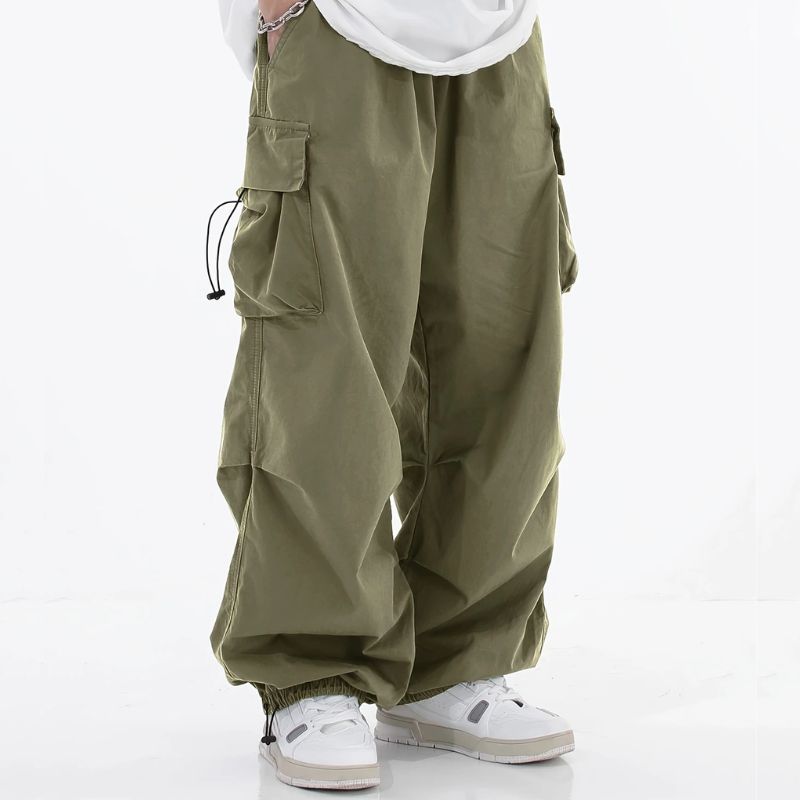 Malvor wide-leg cargo pants in neutral tone with drawstring cuffs and utility pockets, loose tapered fit