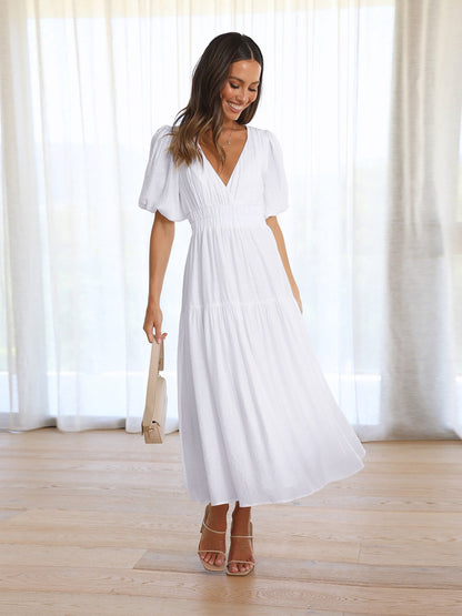 Black V-neck midi dress with puff sleeves and smocked waist, flowing feminine silhouette