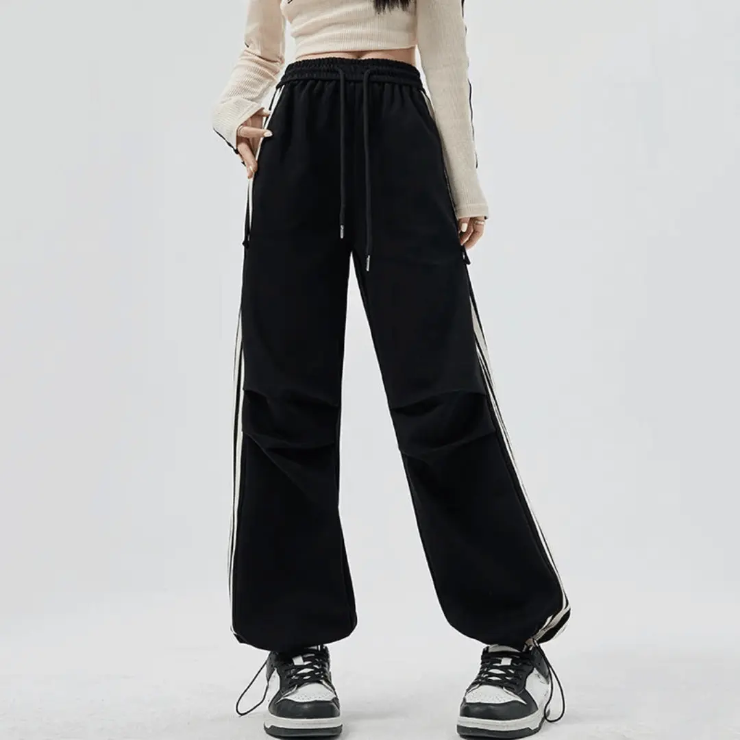 Black wide-leg pants with bold side stripes, oversized pockets, and relaxed sporty fit