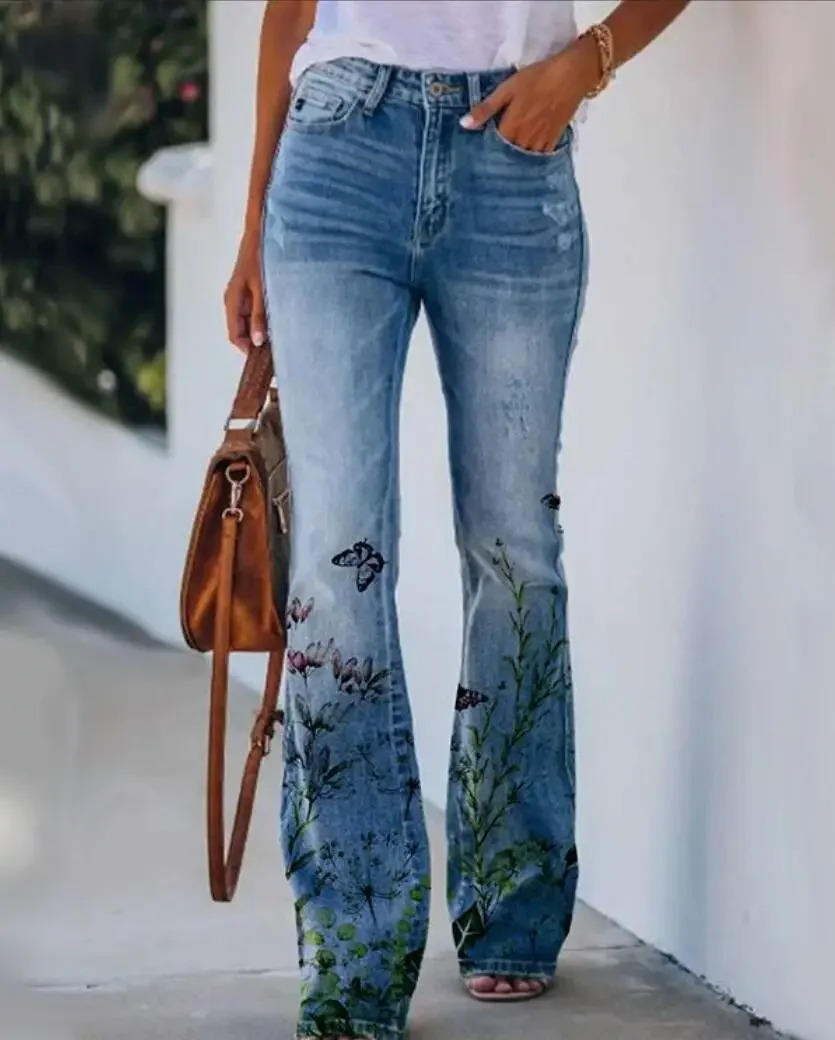 Women's high waist flare jeans with botanical floral print blooming across the flared denim hem