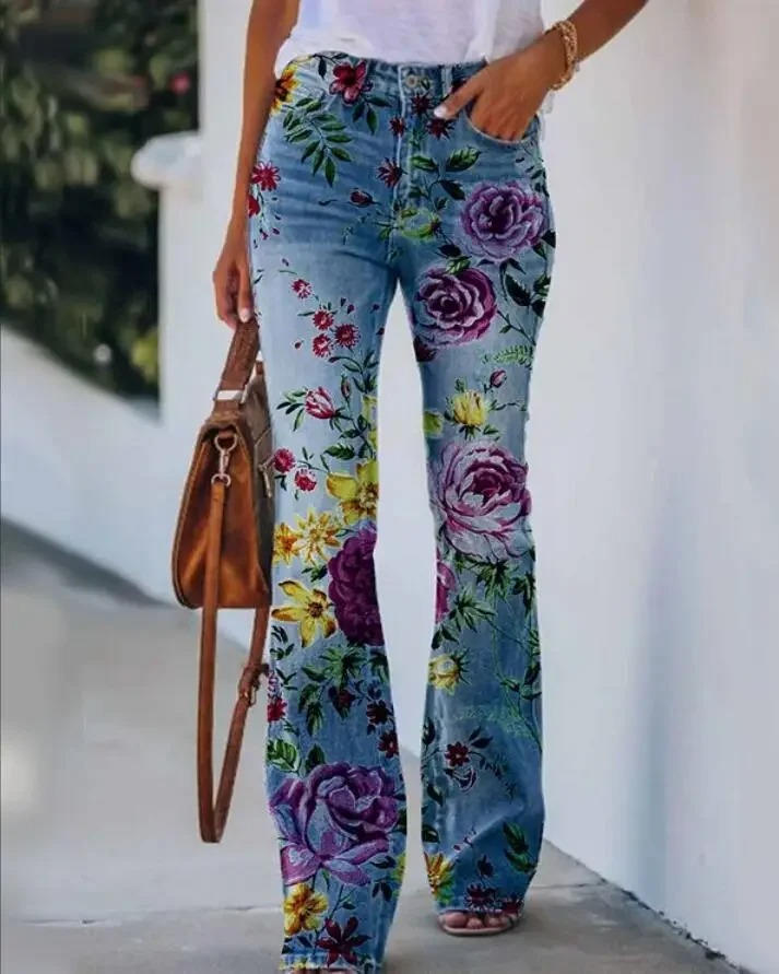 Women's high waist flare jeans with botanical floral print blooming across the flared denim hem