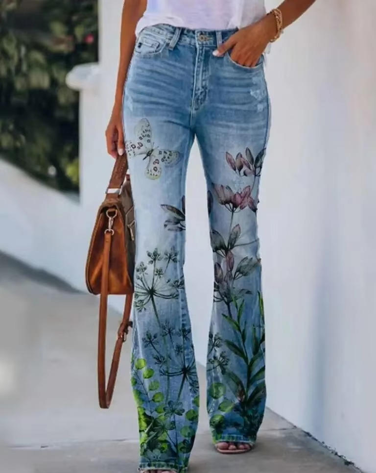 Women's high waist flare jeans with botanical floral print blooming across the flared denim hem