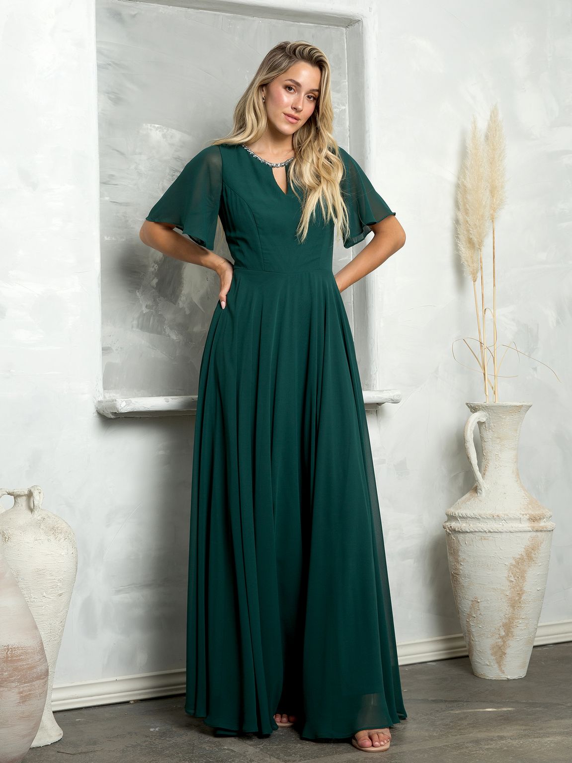 Long beaded chiffon mother of the bride gown with empire waist, bell sleeves, and hidden pockets