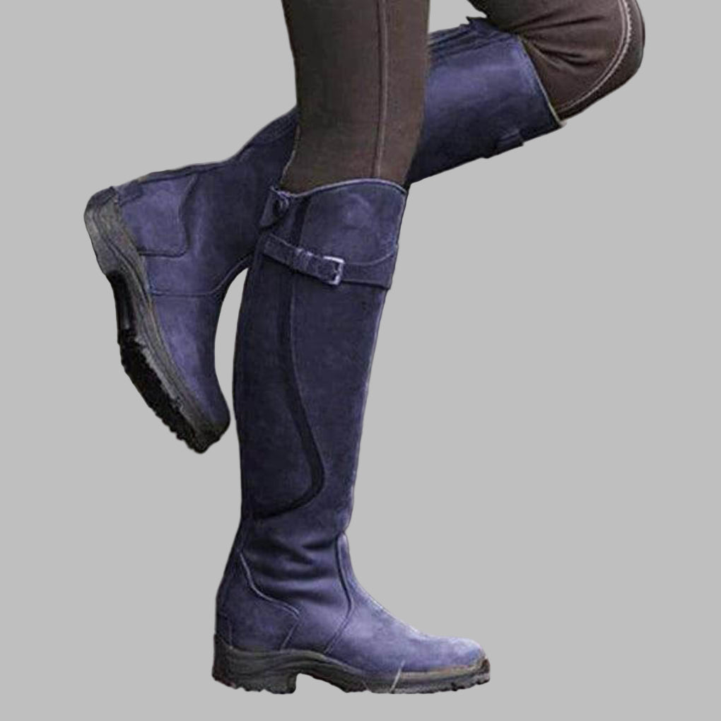 Women's knee-length distressed brown leather hiking boots with buckled strap design and tall silhouette